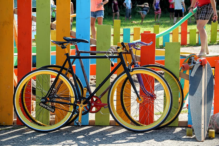 two black road bikes parked beside fence, bicycles, colorful