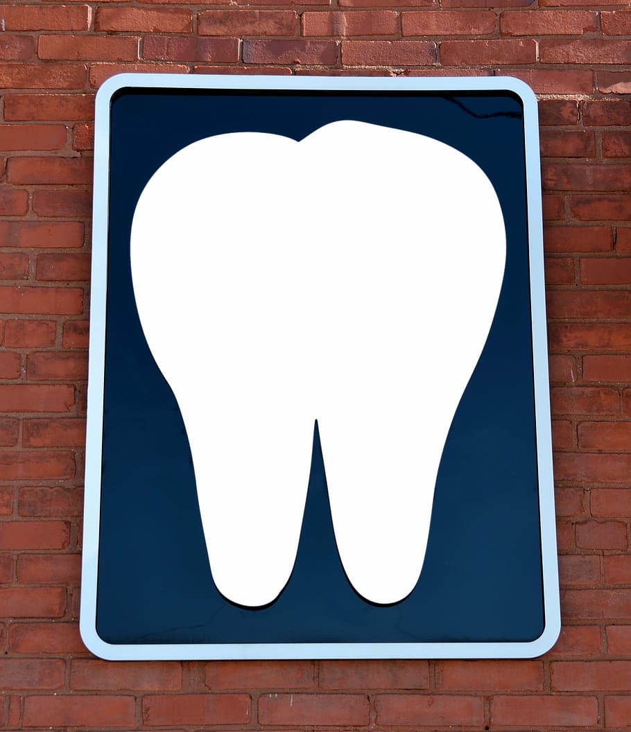white tooth board on brown brick wall, dentist office, sign, background