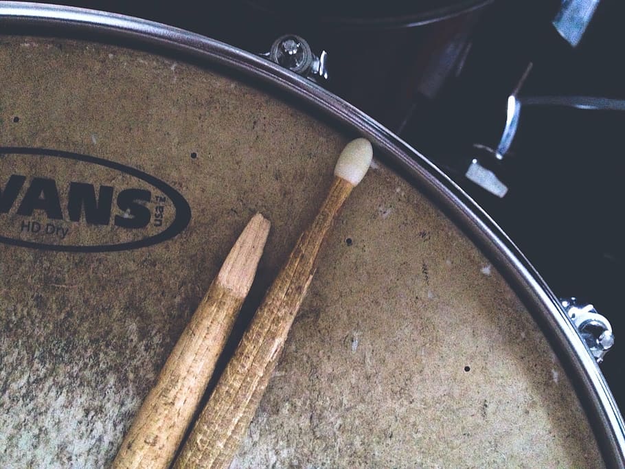 brown drumsticks on brown Vans snare drum, broken drumstick, close-up