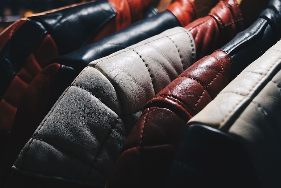 brown leather pad, selective focus photography of hanged leather apparels, HD wallpaper