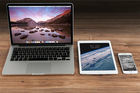 MacBook Pro beside white iPad and silver iPhone 6s on brown wooden desk HD wallpaper