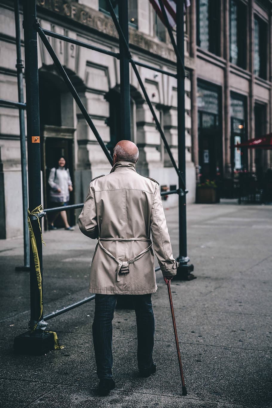 man walking near scaffolding during daytime, man using cane while walking on street in front of building, HD wallpaper