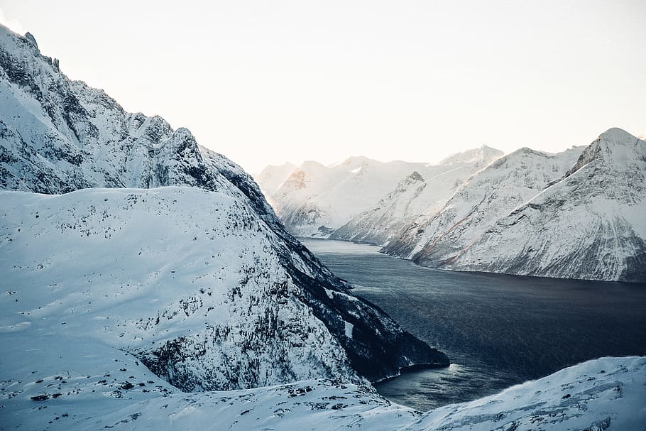 landscape photography of snow-coated mountains near body of water during daytime, blue lake between mountains covered in snow at daytime screenshot HD wallpaper