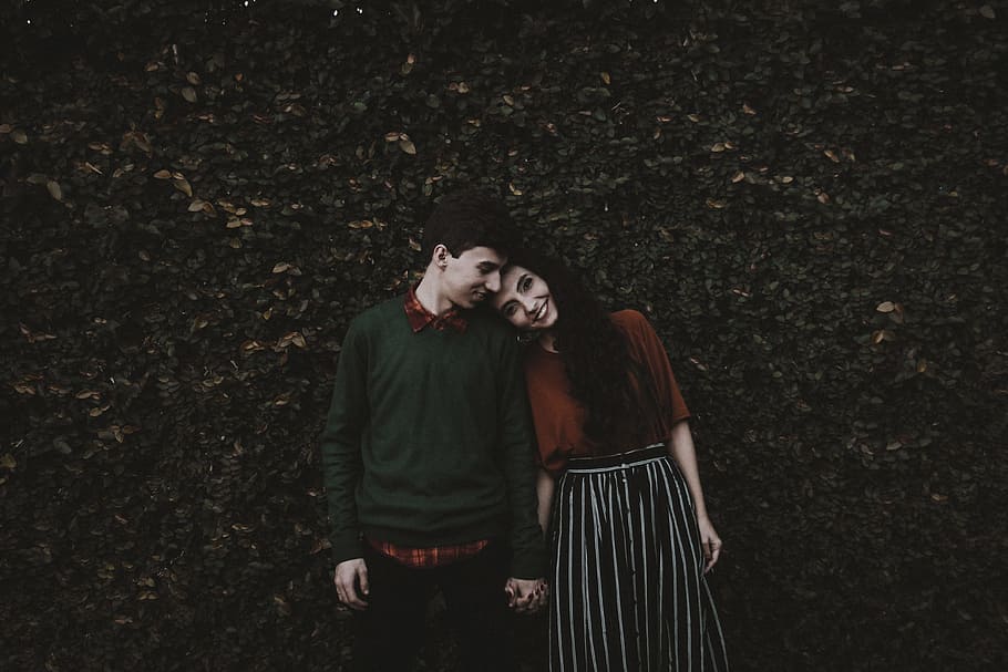 man and woman smiling each other, man and woman taking photo in front of plant wall HD wallpaper