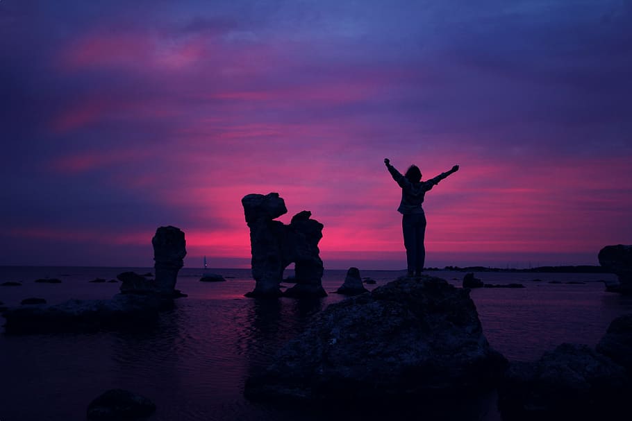 person standing on rock in front of body of water, silhouette HD wallpaper