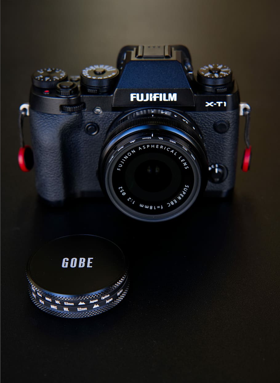 Fujifilm DSLR camera turned-on, black Fujifilm X-TI camera near camera lens lid