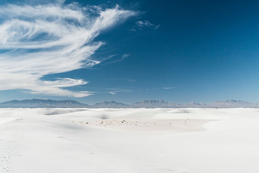 desert during daytime, white sand, mountain range, blue sky, dune