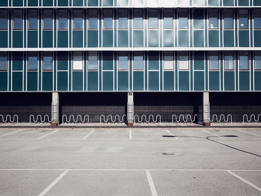 gray concrete framed glass building, gray asphalt parking lot HD wallpaper