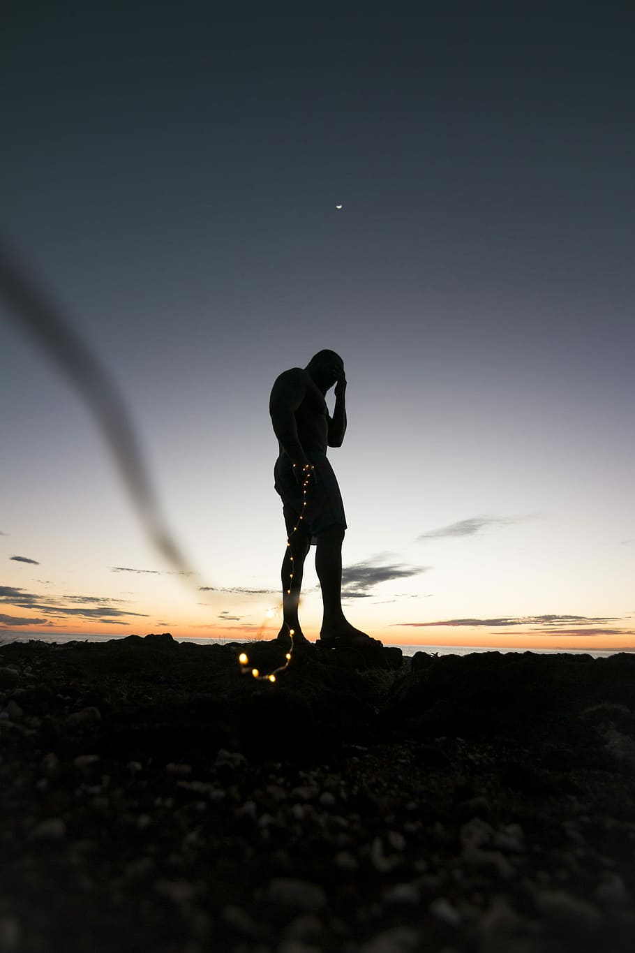 silhouette of person standing on rock during sunset, silhouette of man holding string lights during golden hour HD wallpaper