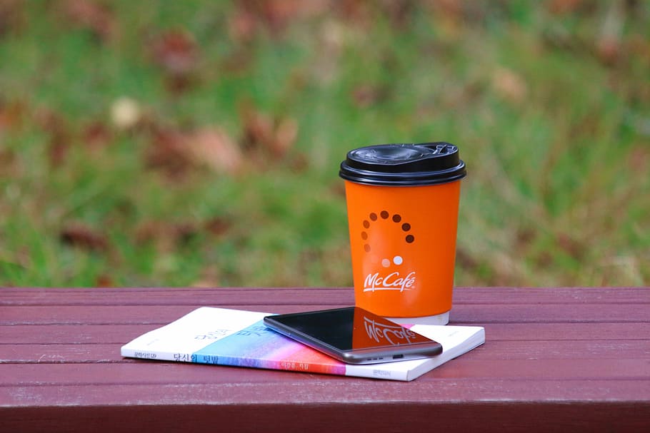 red Mc Cafe cup beside black Android smartphone, autumn, bench, HD wallpaper