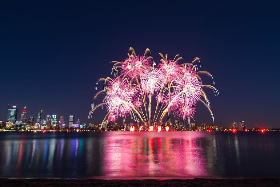 fireworks display, pink and brown fireworks display, night, city