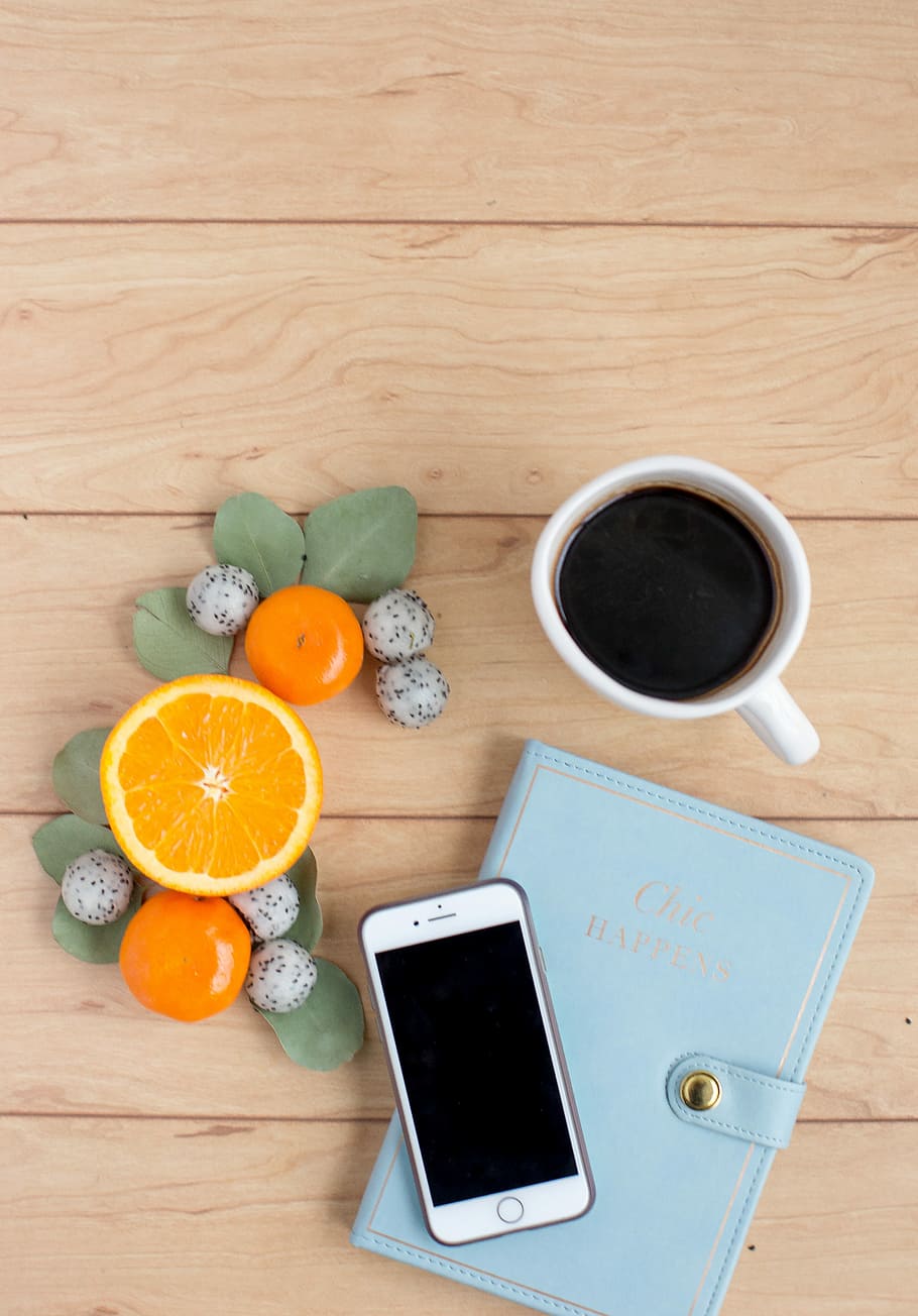 silver iPhone on book near coffee, silver iPhone near white ceramic mug filled with black coffee HD wallpaper