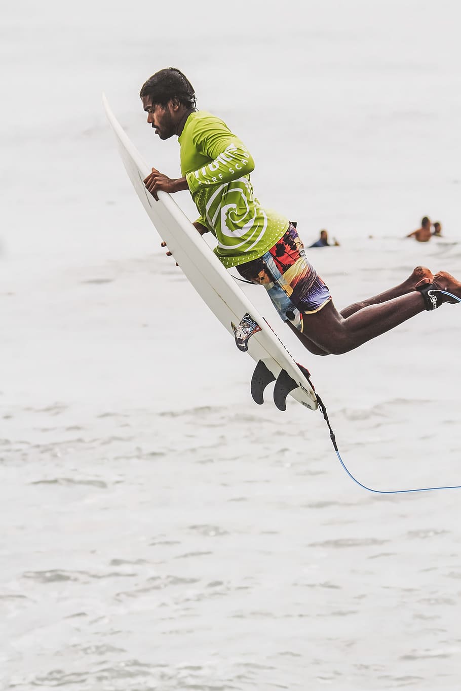 man wearing green long-sleeved shirt and white surfboard, man wearing green long-sleeved shirt and red broadshorts holding white surfboard HD wallpaper