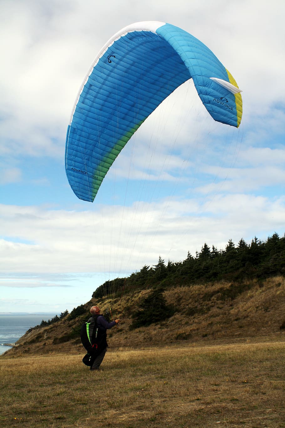man riding blue parachute, sky, diver, touching, green, grass HD wallpaper