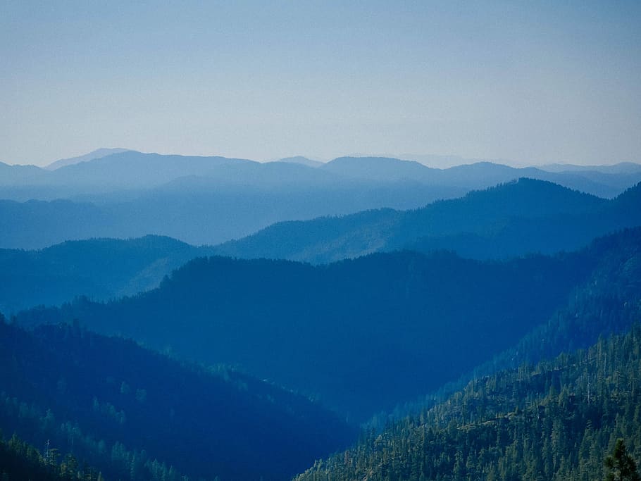 green trees on mountains during daytime, aerial view photography of mountains under clear blue sky during daytime HD wallpaper