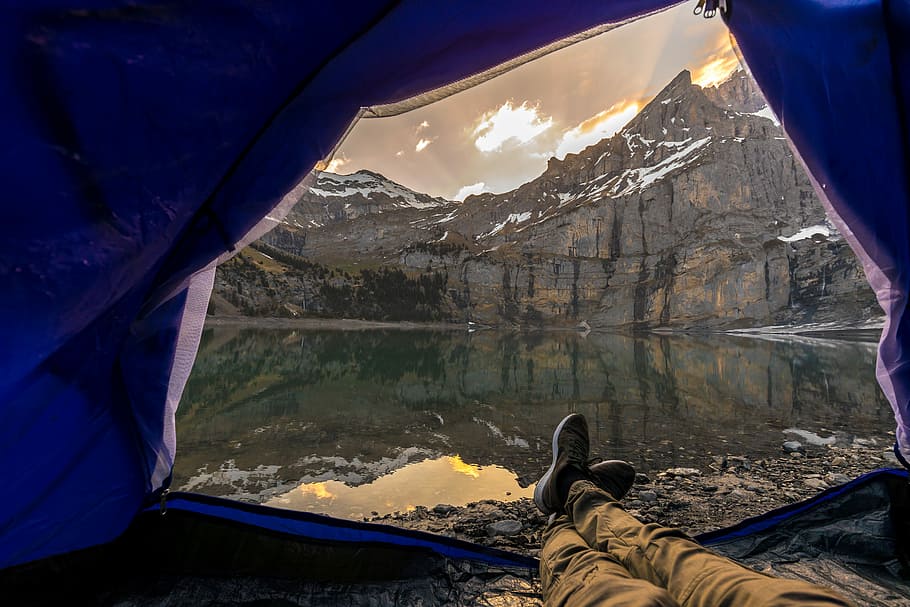 person laying inside of tent in front of body of water, adventure HD wallpaper