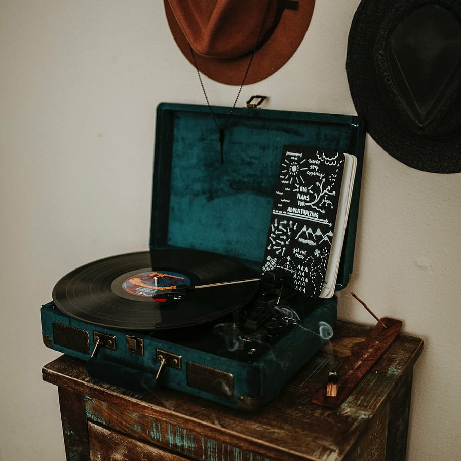 phonograph on side table, wall, hats, notes, notebook, smoke