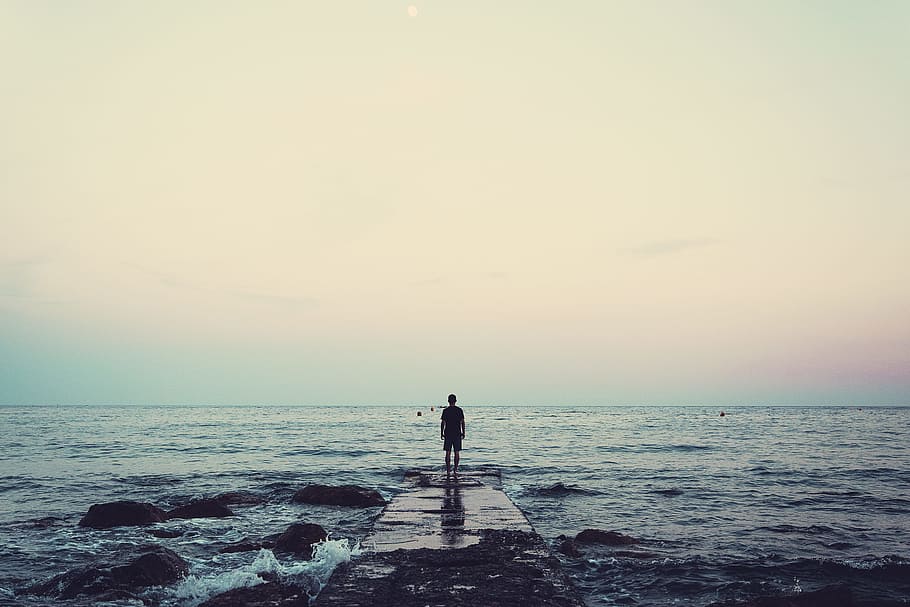 silhouette of person standing on sea dock under cloudy sky, man standing on wooden dock in the middle of body of water, HD wallpaper