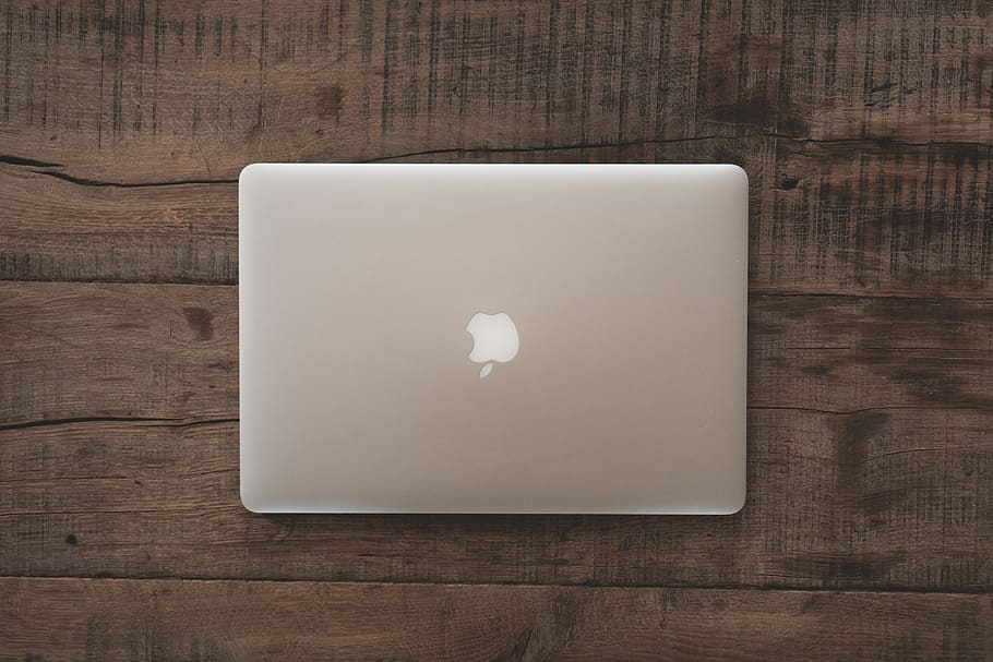 closed silver MacBook on table, MacBook Pro on brown surface, HD wallpaper