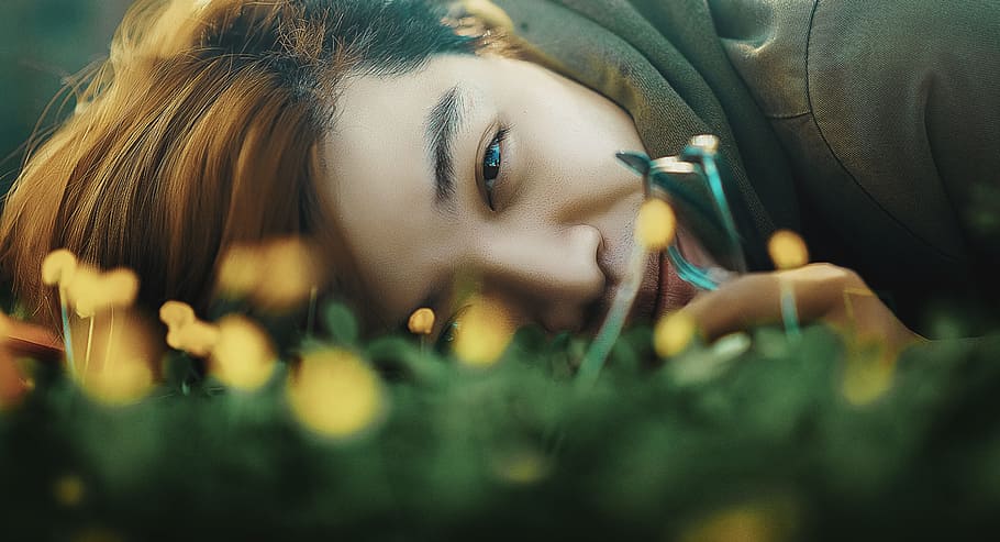 selective focus photography of person lying on grass field HD wallpaper