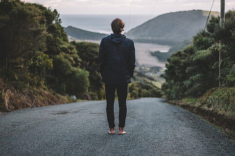 man standing on black asphalt road towards mountain, person HD wallpaper