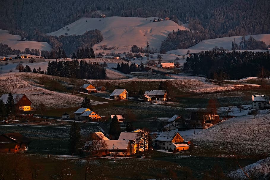 aerial photography of houses near snow-capped mountain at daytime, houses on snowy ground overlooking clouds at daytme HD wallpaper