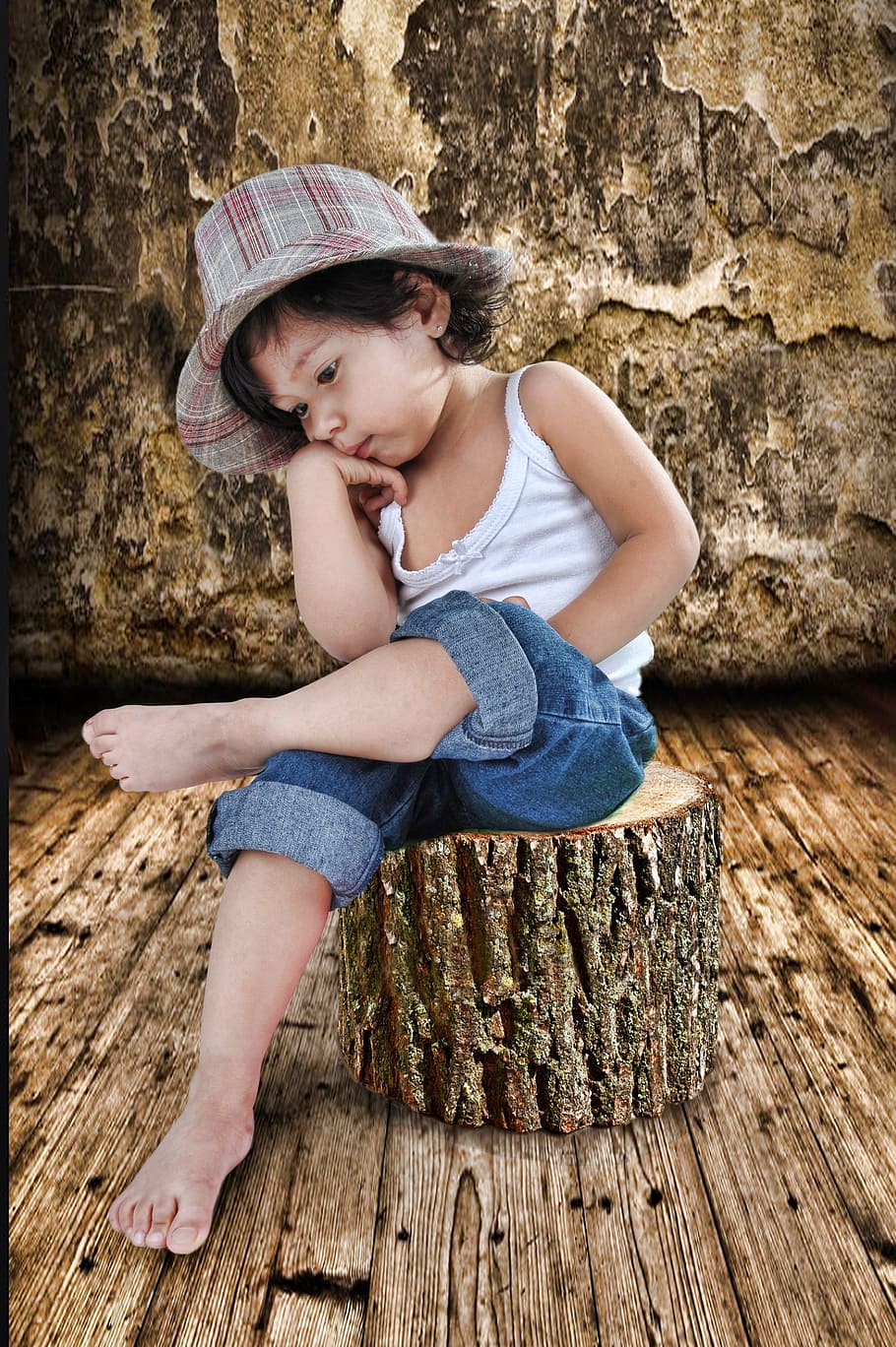 girl in white spaghetti strap shirt and blue denim jeans sits of brown tree log HD wallpaper