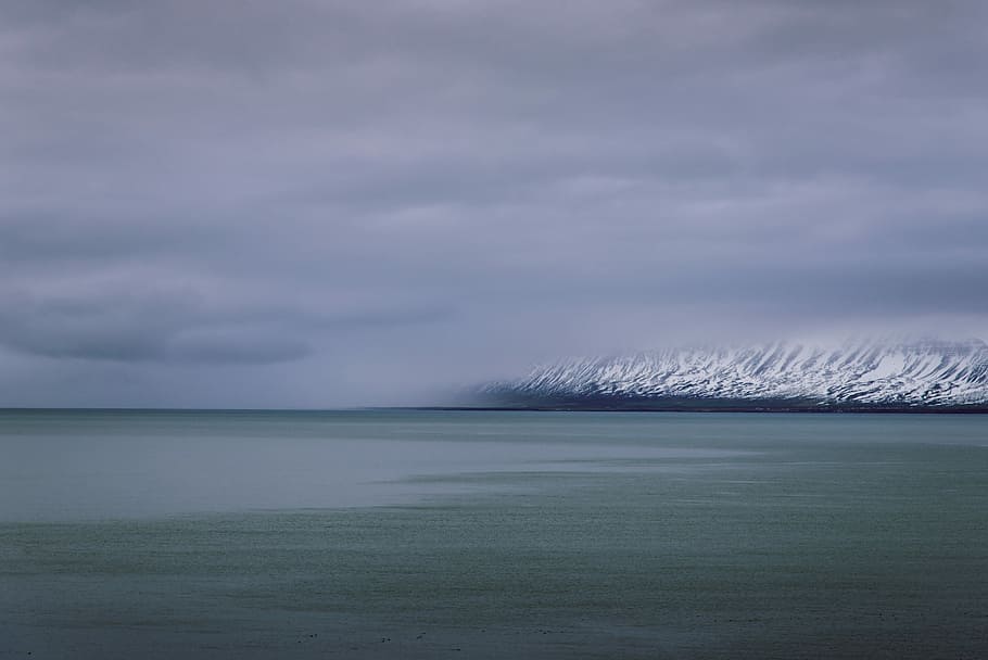 ocean beside of snow mountain, long exposure photography of body of water near mountain HD wallpaper