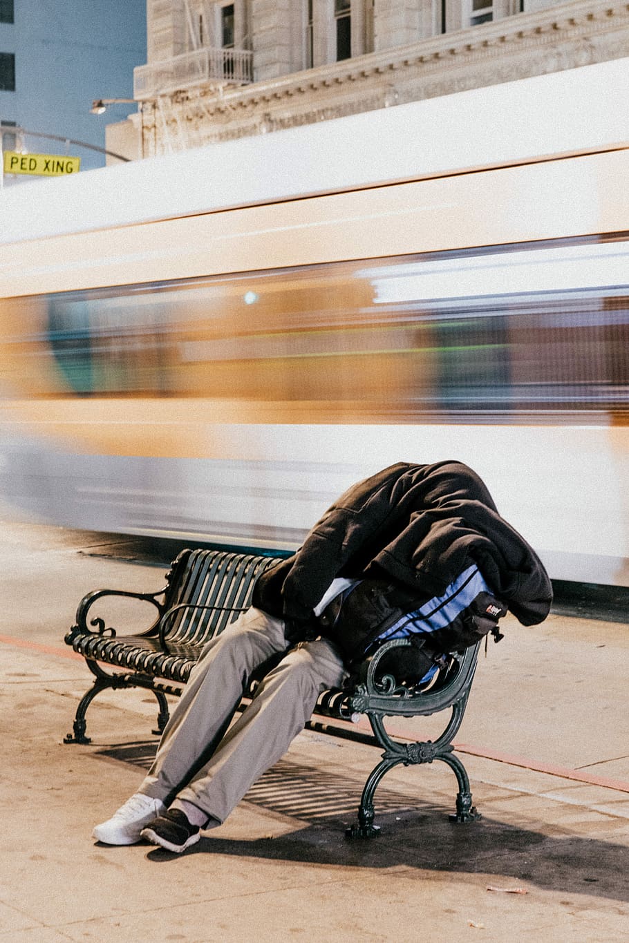 person sleeping on black steel bench, long exposure photography of sitting person wearing black hoodie, khaki pants and sneakers on black metal bench beside street HD wallpaper