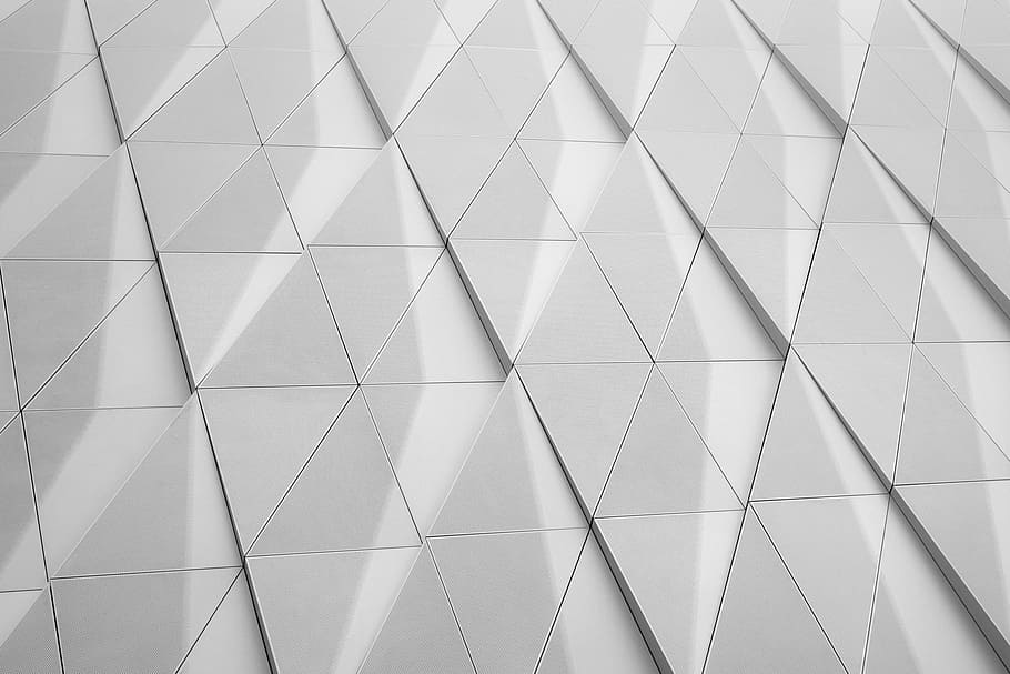 A white facade with a geometric pattern made up of triangles, close photo of triangle accent wall