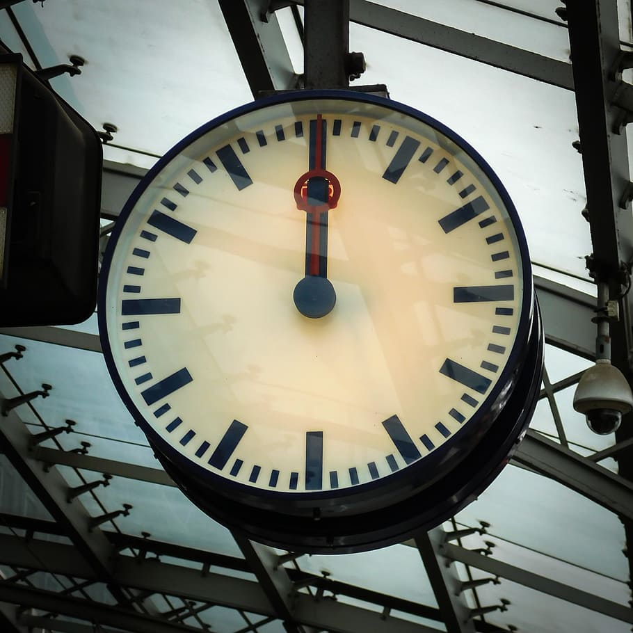 analog wall clock reading at 12:00, railway station, station clock