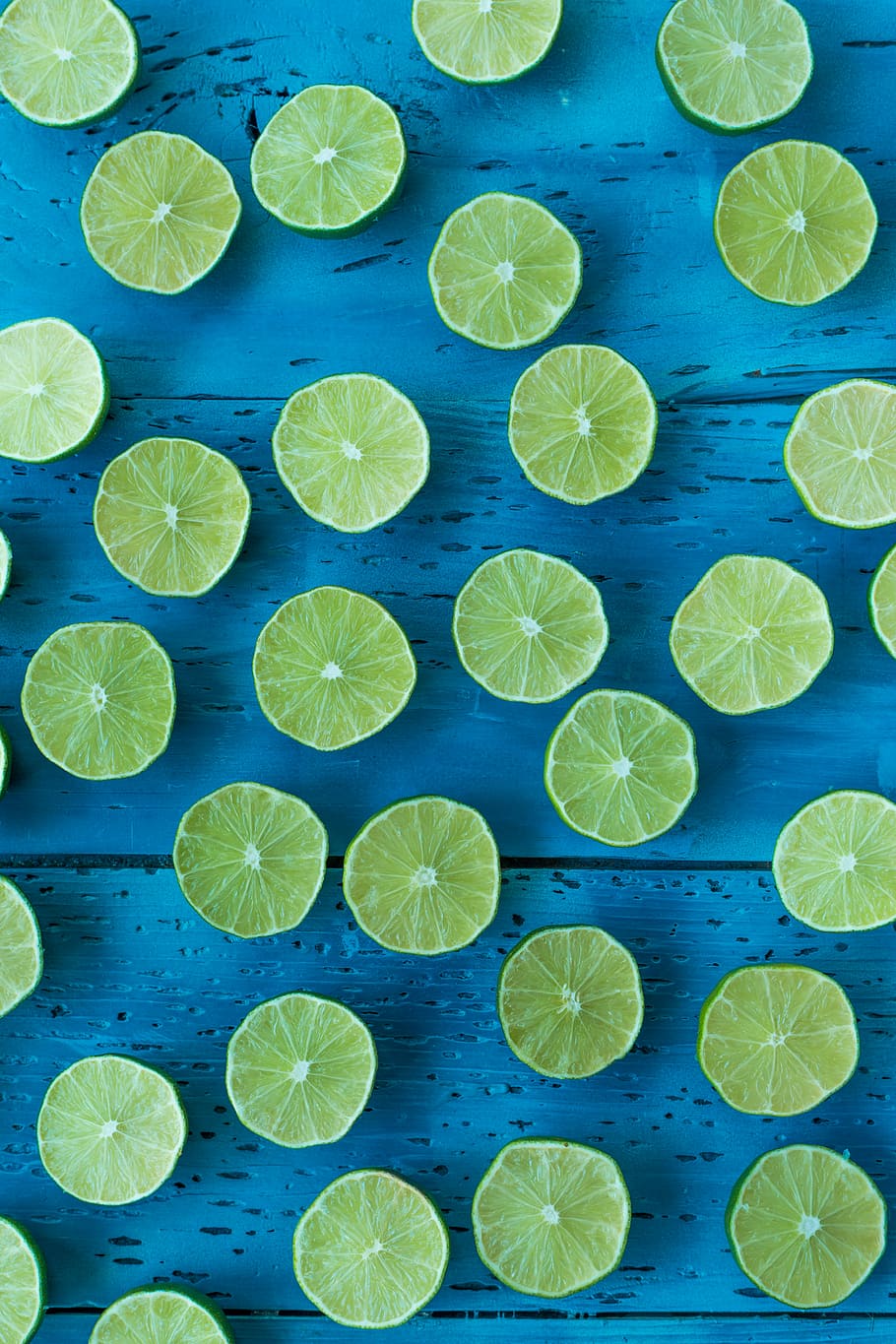 Slices of lime of a blue background, sliced lime on blue wooden board HD wallpaper