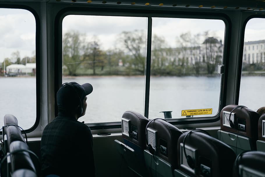 man inside vehicle looking at building near body of water, man leaning at window during daytime HD wallpaper