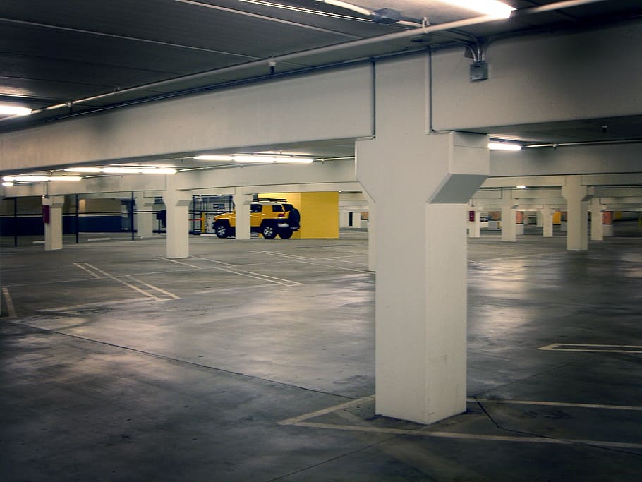 yellow Toyota FJ Cruiser parked on underground parking lot, parking deck