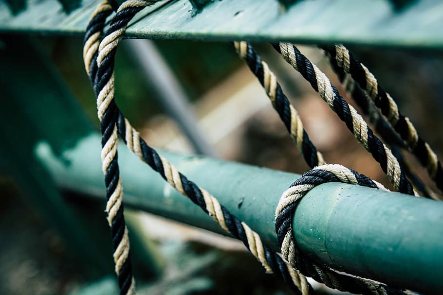 closeup photo of tie black rope on green metal rod, black and white striped rope HD wallpaper