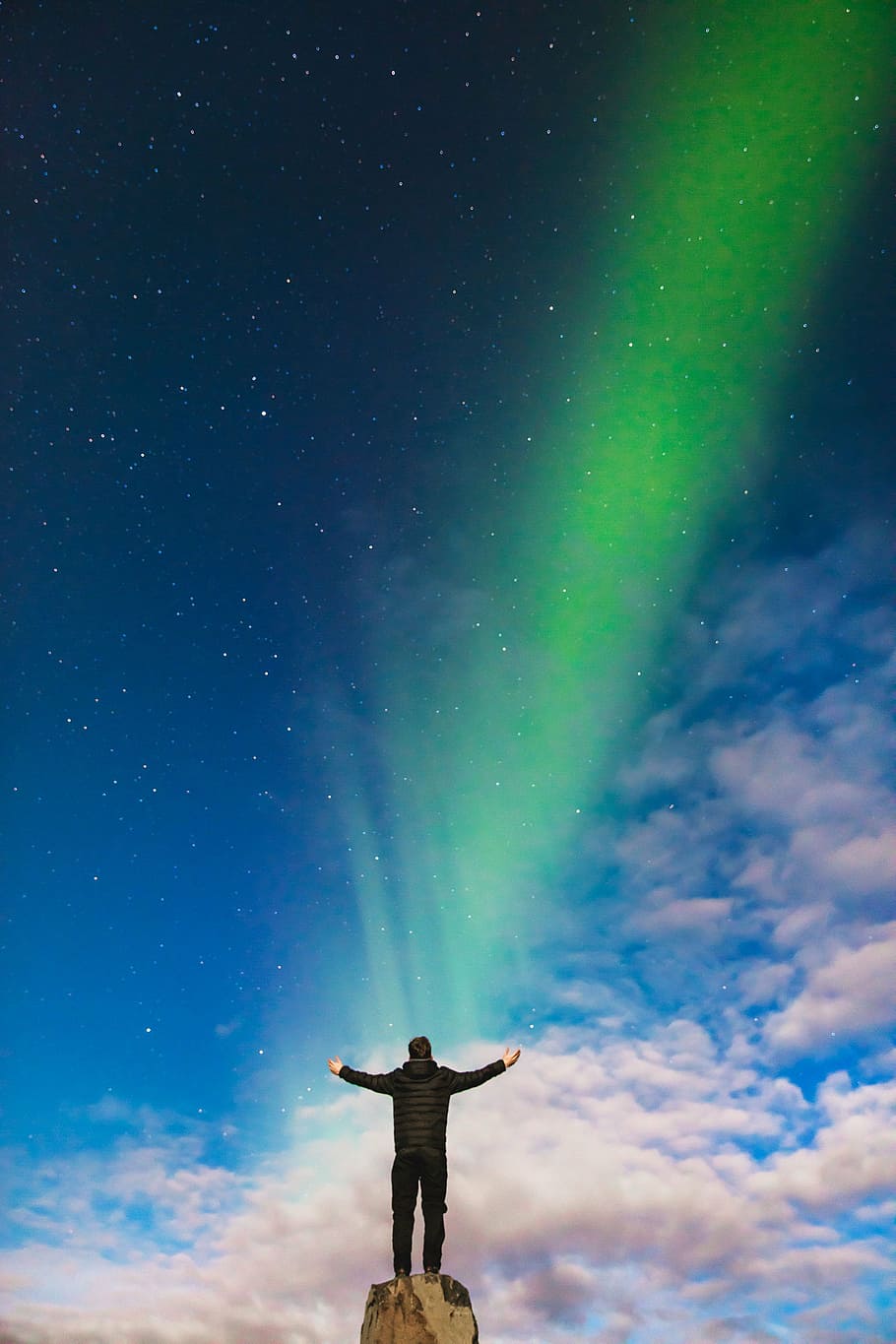 man standing on brown rock formation under Aurora Borealis during daytime HD wallpaper
