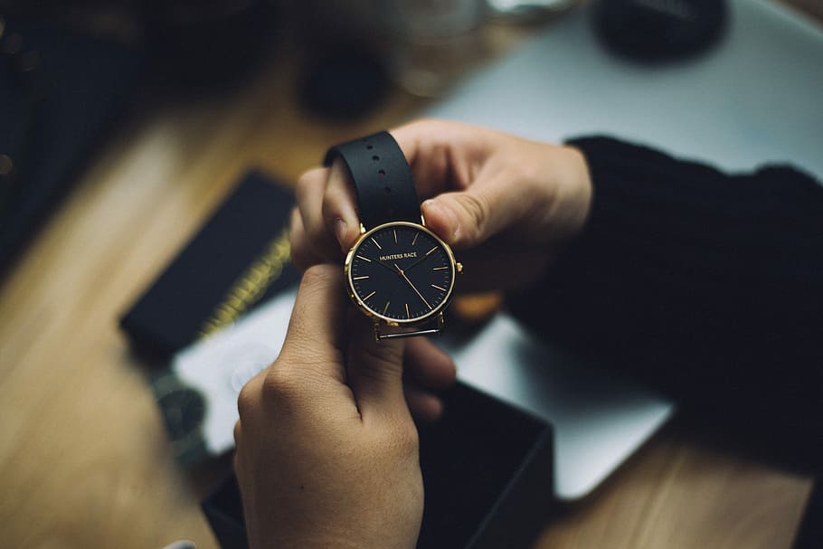 person holding gold-colored analog watch with black strap, person holding round gold-colored analog watch HD wallpaper