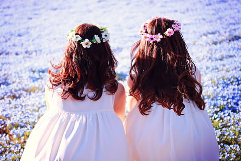 two girls wearing sleeveless dress and floral headband sitting on purple petaled flower garden HD wallpaper