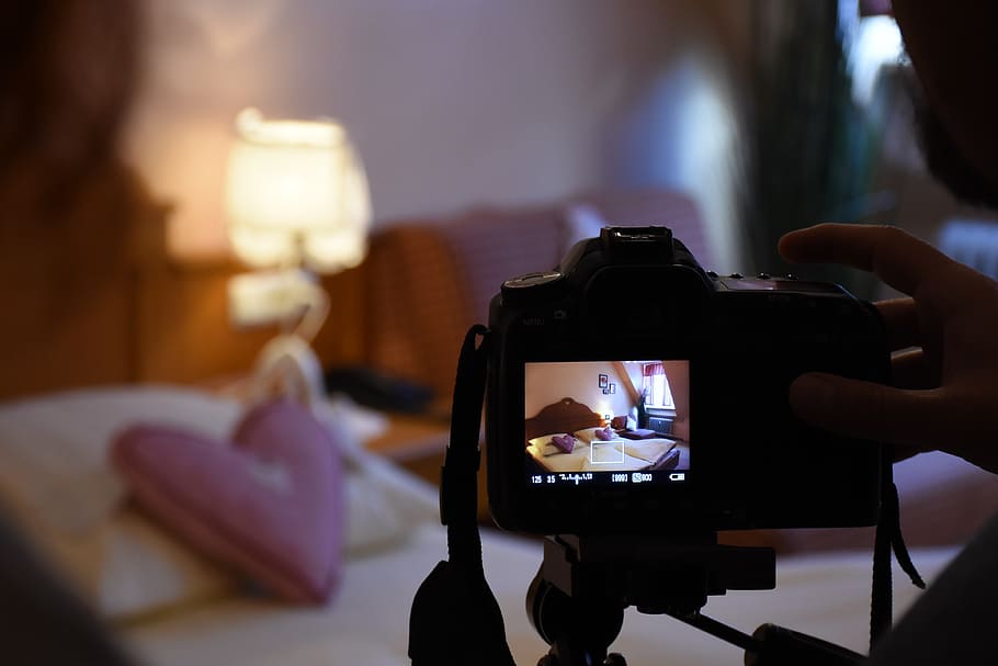 person taking photo of bed, photo shoot, photographer, digital camera