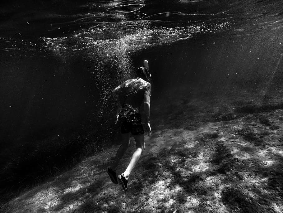 grayscale photography of man swimming underwater, grayscale photography of person diving