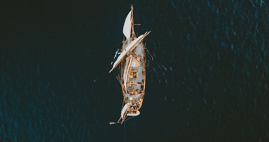 aerial view photography of ship on body of water, aerial photography of brown and white sailboat