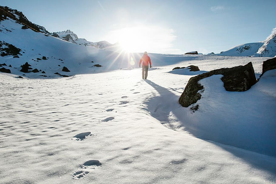 person walking on snow field at daytime, mountain, highland HD wallpaper