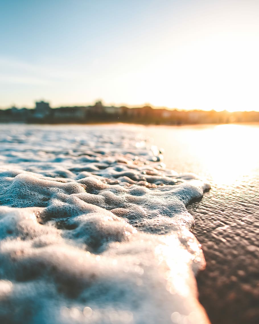 close photography of sea, close-up photography of ocean wave on shore overlooking sunset HD wallpaper