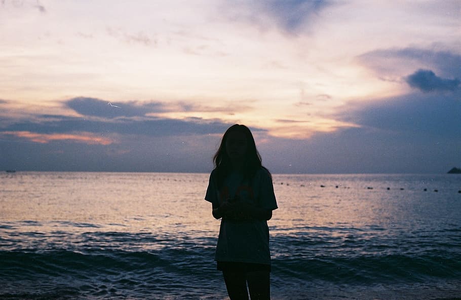 Silhouette of Woman Standing Near Large Body of Water, backlit HD wallpaper