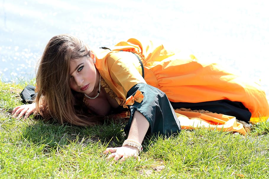 woman lying on green grass near body of water at daytime, Girl
