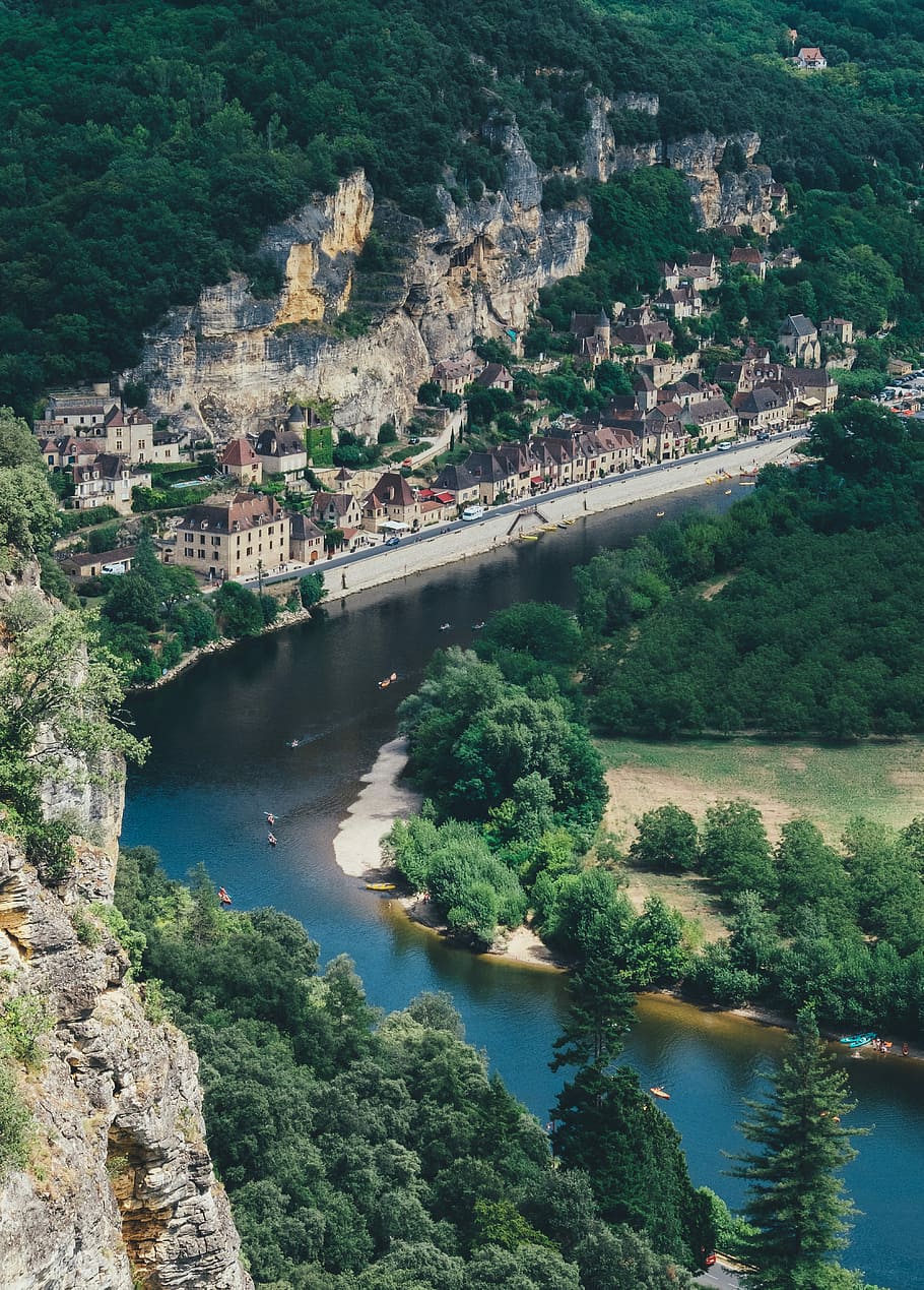 aerial view of building beside water, aerial photography of river beside village surrounded by green mountain HD wallpaper