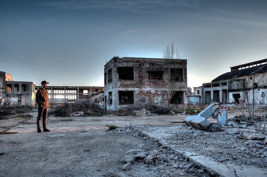 man standing near 2-story concrete building, hdr, destroyed area