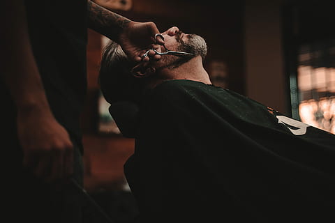 man sitting on barber's chair, man cutting another man's beard HD wallpaper