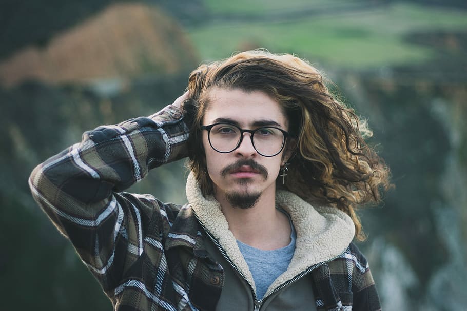 selective focus photography of man holding his hair wearing black and green zip-up hoodie and crew-neck shirt, man holding his hair HD wallpaper