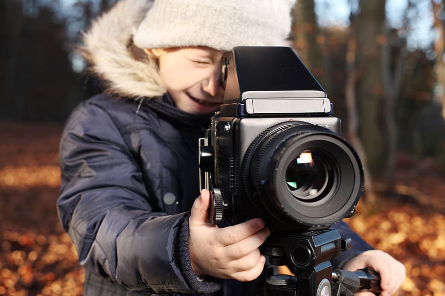 selective focus photography of boy taking a photo, photographer
